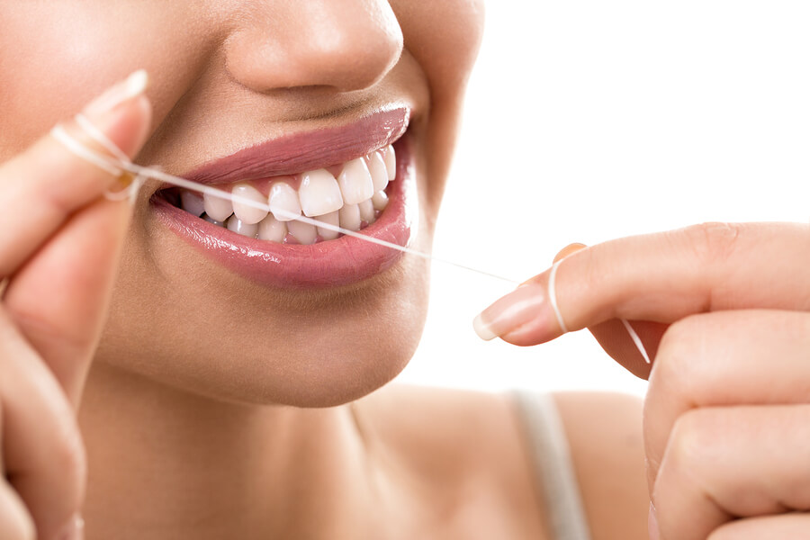 young woman flossing, close up of teeth