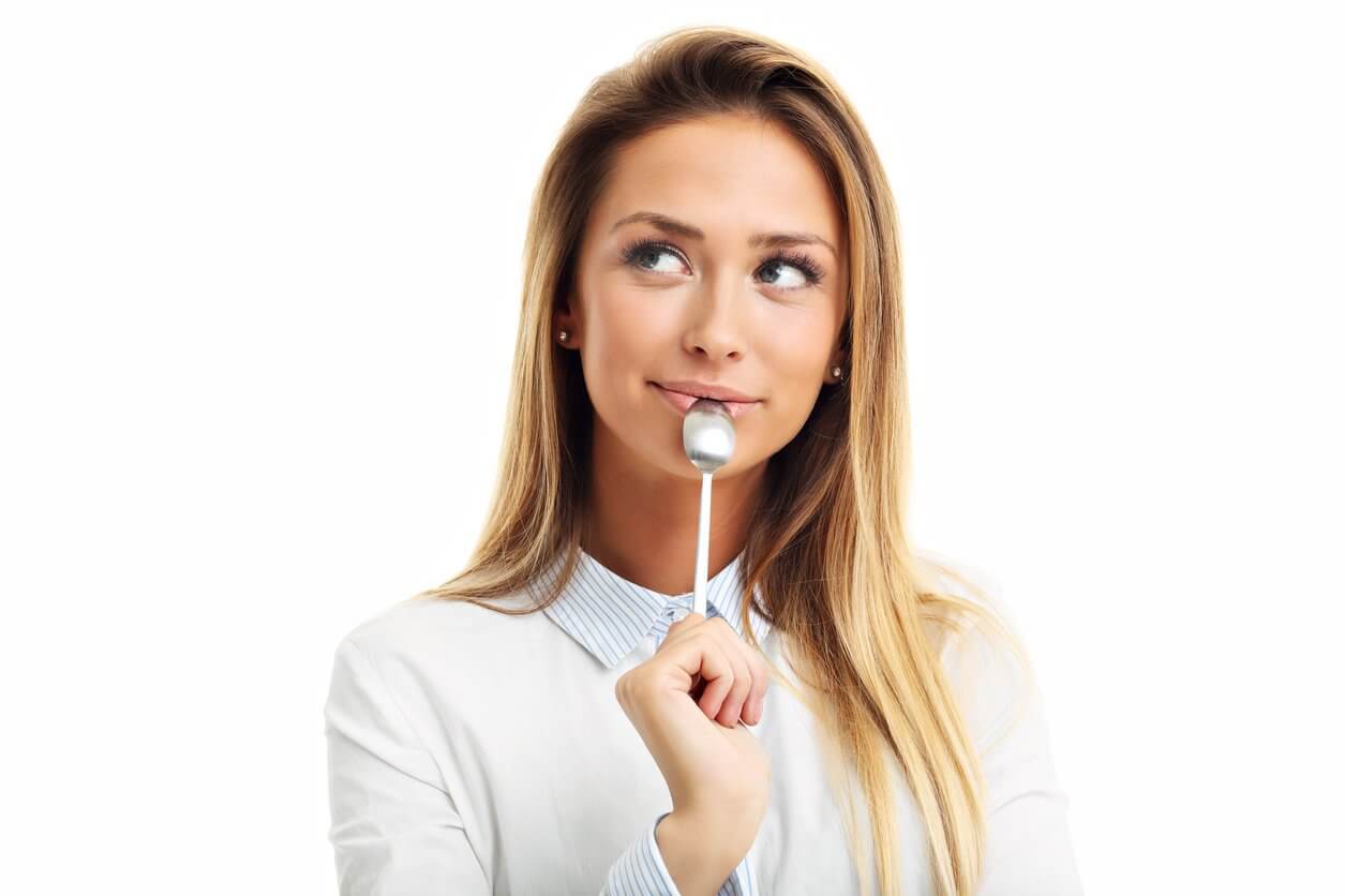 young smiling woman with spoon in her mouth