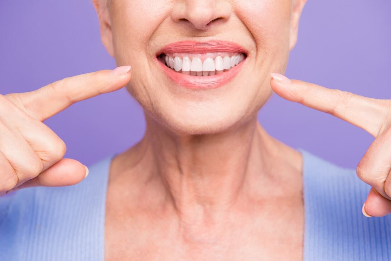 Cropped portrait of beaming smile female pointing at her teeth,