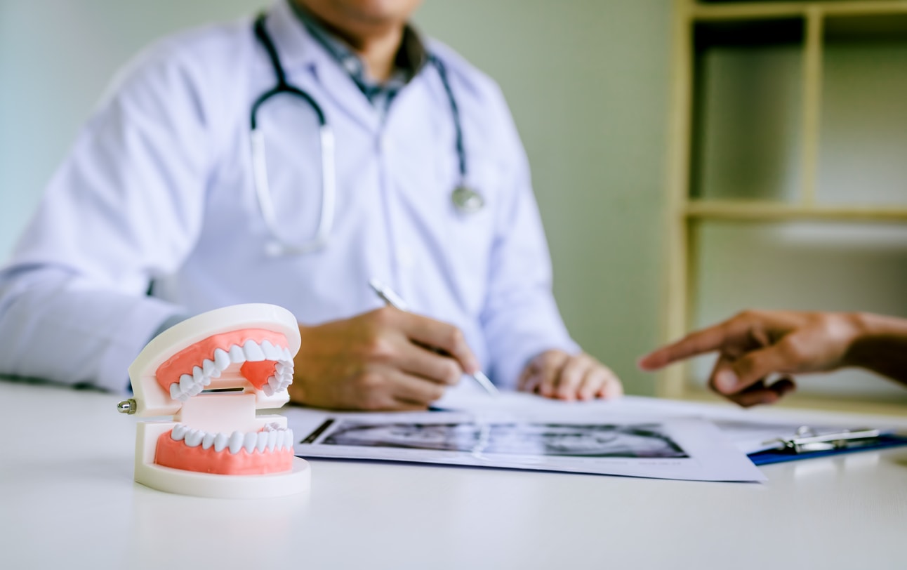 Dentist discussing patient x-rays, dentures in foreground